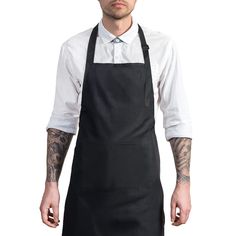 a man with tattoos wearing an apron