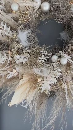 a wreath with white balls and feathers on it