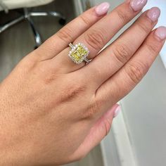 a woman's hand with a yellow and white diamond ring