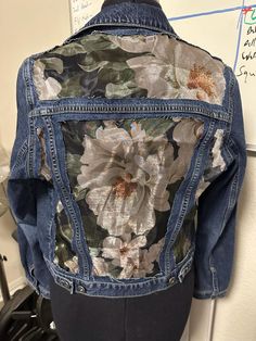 the back of a jean jacket with flowers on it