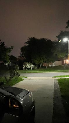 a car parked on the side of a road at night