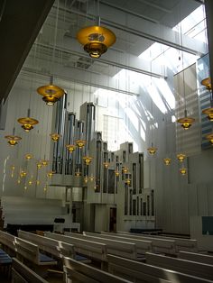 the interior of a church with many lights hanging from the ceiling and organ pipes in the background