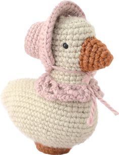 a crocheted stuffed duck wearing a pink hat and scarf sitting on top of a white table