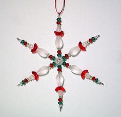 a christmas ornament with red, green and white beaded decorations on it