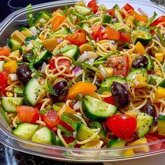 a bowl filled with pasta and veggies on top of a table