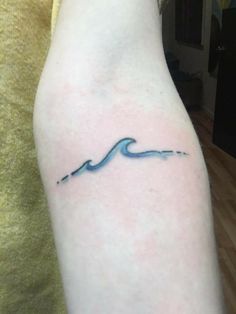 a small wave tattoo on the arm