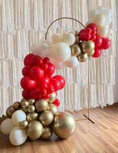 a bunch of balloons that are in the shape of a tower on a wooden floor