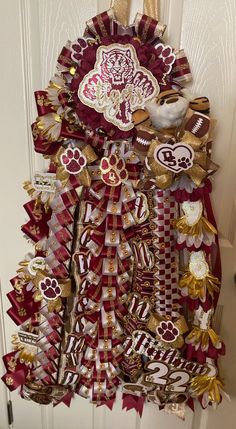 a door hanger decorated with red and gold ribbons