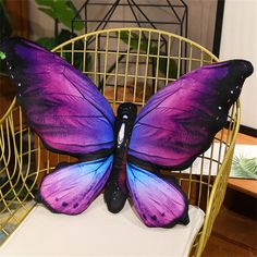 a purple and blue butterfly sitting on top of a chair