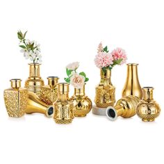 several gold vases with flowers in them