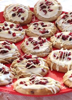 cookies with white icing and cranberries on a red plate