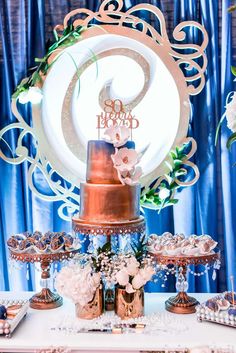 a table topped with a cake covered in frosting next to other desserts and decorations