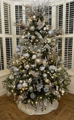 a decorated christmas tree with silver and white ornaments