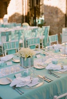 the table is set with white flowers and place settings for an elegant dinner or reception