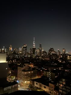 the city skyline is lit up at night with buildings in the foreground and lights on