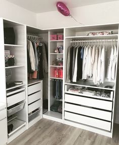 a white closet filled with lots of clothes