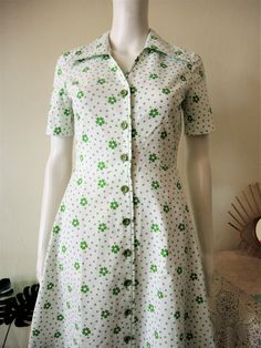 Cute True Vintage mini dress from the 1970s. Fitted top and wide skirt. Comfortable cotton fabric with a fresh green floral print. Large pointed lapel collar, short sleeves. Button down, unlined. Made in UK! Looks great with a pair of sneakers. BRAND: St. Michael ERA: 1970s COLOR: White, green FABRIC: 100% cotton SIZE: Vintage size EU 38, UK 10, fits best size XS - please check measurements below for reference MEASUREMENTS: Pit to pit 42cm, single waist 32cm, total length 91cm CONDITION: Very go Vintage Green Collared Dress, Retro Collared Floral Print Dresses, Retro Collared Dresses With Floral Print, Retro Floral Print Collared Dress, Retro Collared Dress With Floral Print, Green Collared Cotton Dress, Green Cotton Collared Dress, 1979 Fashion, House Keeper