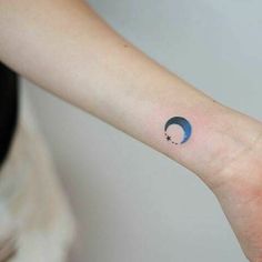 a woman's arm with a small crescent tattoo on the left side of her wrist