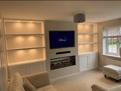 a living room filled with furniture and a flat screen tv mounted on a wall above a fire place