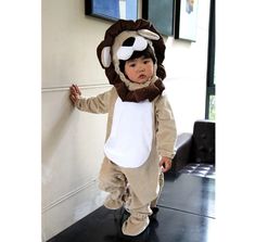 a little boy dressed in a lion costume