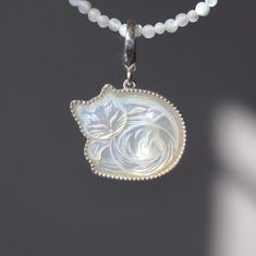 Mother of Pear Golden Cat Charm Necklace Carved mother of pearl Charm Necklace Silver Golden South Sea Pearl Kitty Handmade Necklace  Adorn yourself with this charming necklace featuring a mother of pearl pendant carved into an adorable sleeping cat. Set in a bezel with delicate milgrain detailing, the pendant captures the serene beauty of a resting feline. The high-quality sterling silver chain complements the pendant, adding a touch of elegance and durability. Perfect for cat lovers and fans of unique, handcrafted jewelry, this necklace brings a playful yet sophisticated touch to any outfit. Whether a special gift or a delightful addition to your collection, this piece is sure to enchant and impress. Measurement: Each Cat 18mm*17mm. necklace.  Length: 45cm/18inch to 40cm/16inch adjustabl Adjustable White Jewelry With Cat Design, Adjustable White Cat Design Jewelry, Elegant White Jewelry With Cat Design, Elegant White Cat Design Jewelry, White Cat Design Jewelry Gift, White Mother Of Pearl Necklace For Mother's Day, Cat Charm Necklace, Golden Cat, Pearl Charm Necklace