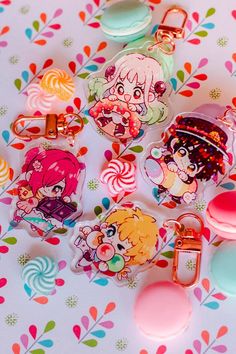 various keychains with cartoon characters on them sitting on a colorful tablecloth,