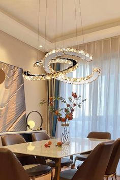 a dining room table with chairs and a chandelier hanging from it's ceiling