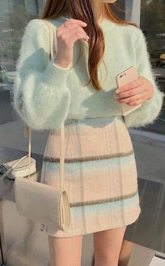 a woman is taking a selfie with her cell phone while wearing a fuzzy sweater