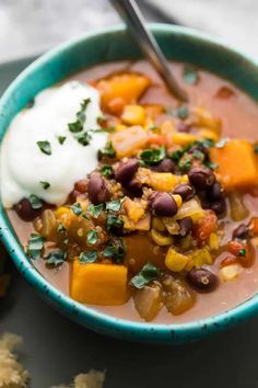 a bowl of soup with beans, corn and sour cream