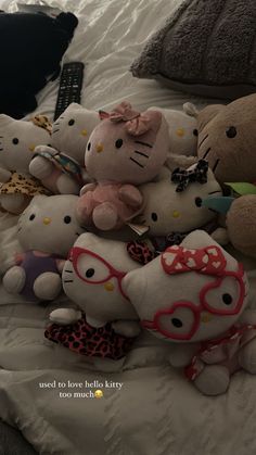 a pile of hello kitty stuffed animals sitting on top of a bed