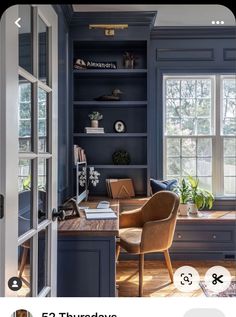 an open book shelf with a chair and desk in front of it, next to a window