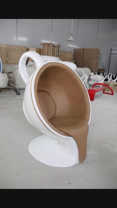 a white and brown chair sitting on top of a cement floor next to other chairs