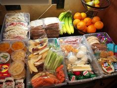 an assortment of fruits, vegetables and meats in plastic containers on a kitchen counter