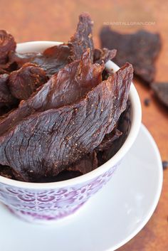 a white bowl filled with beef sitting on top of a table