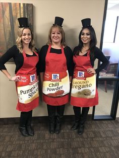 three women wearing red aprons and black hats