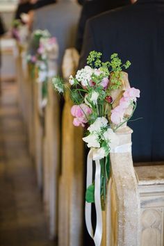 flowers are tied to the back of pews