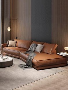 a large brown leather couch sitting in a living room next to a table and lamp