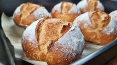 some bread rolls are sitting in a pan on top of wax paper and ready to be baked