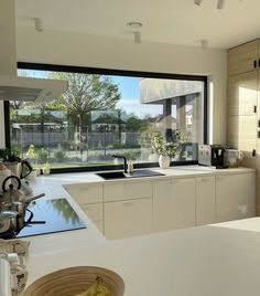 a kitchen with an open window and white counter tops on both sides of the room