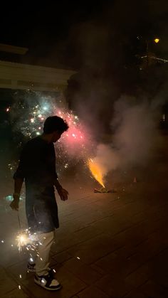 a man standing in front of fireworks at night