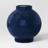 a blue vase sitting on top of a white table