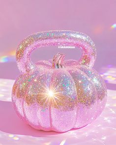 a pink glittered pumpkin shaped purse sitting on top of a table