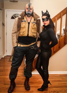 two people dressed up as batman and catwoman standing next to each other on a wooden floor