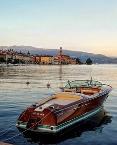 a boat is tied up to the dock in front of an old town and lake