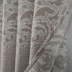 closeup of the fabric on a curtain with an intricate design in grey and white