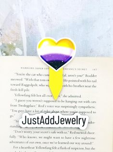 an open book with a heart shaped sticker on the front and back cover that reads just add jewelry