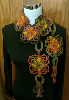 a mannequin wearing a black shirt and multicolored crocheted scarf