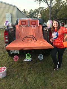 a woman standing next to a truck with an orange cover on it