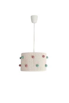 a white lamp with pink, green and blue dots hanging from it's ceiling