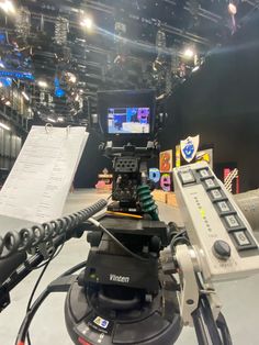 a video camera sitting on top of a tripod in front of a microphone and sound board